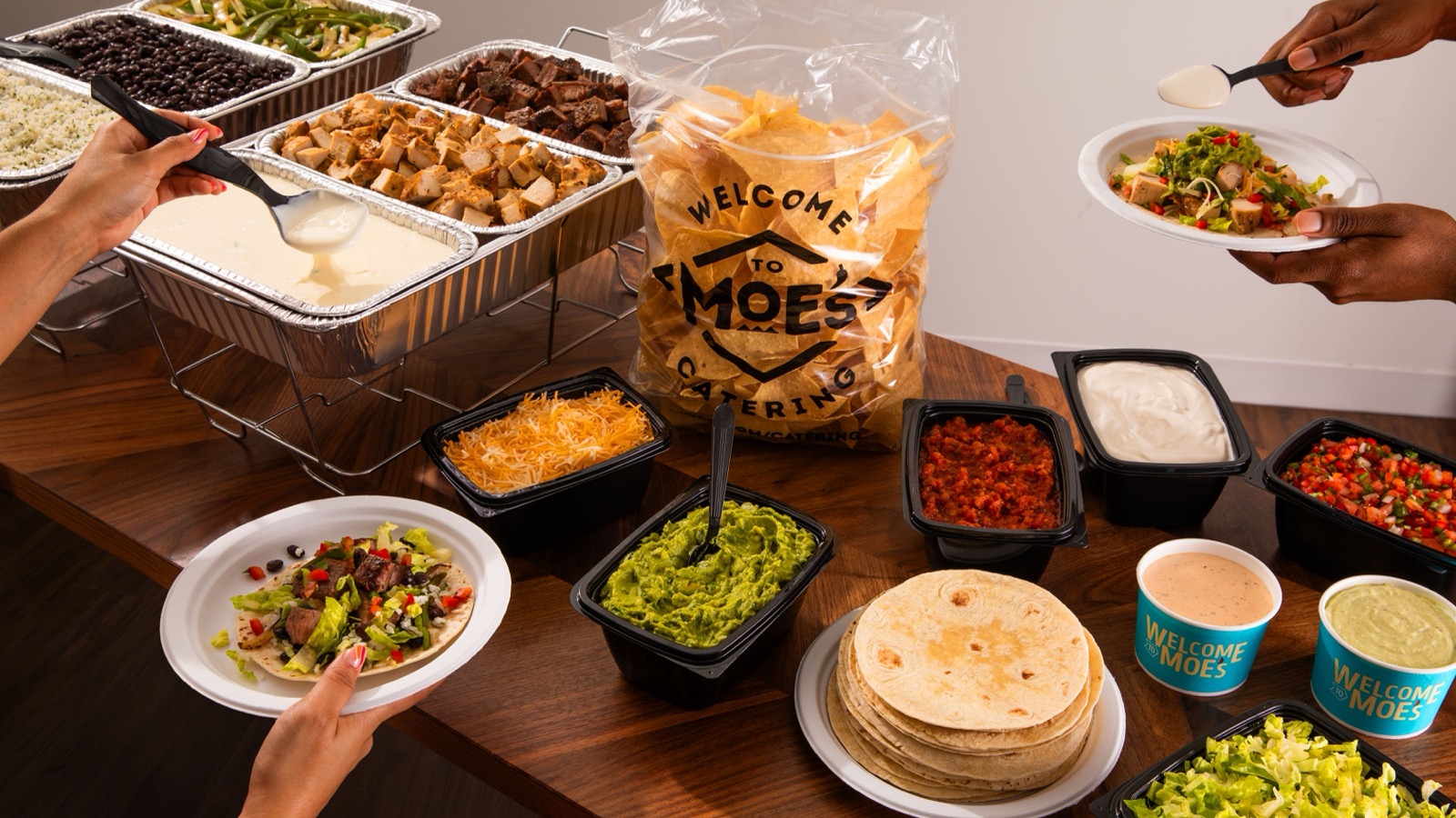 Moe's fajita bar catering with proteins, vegetables, chips, and toppings
